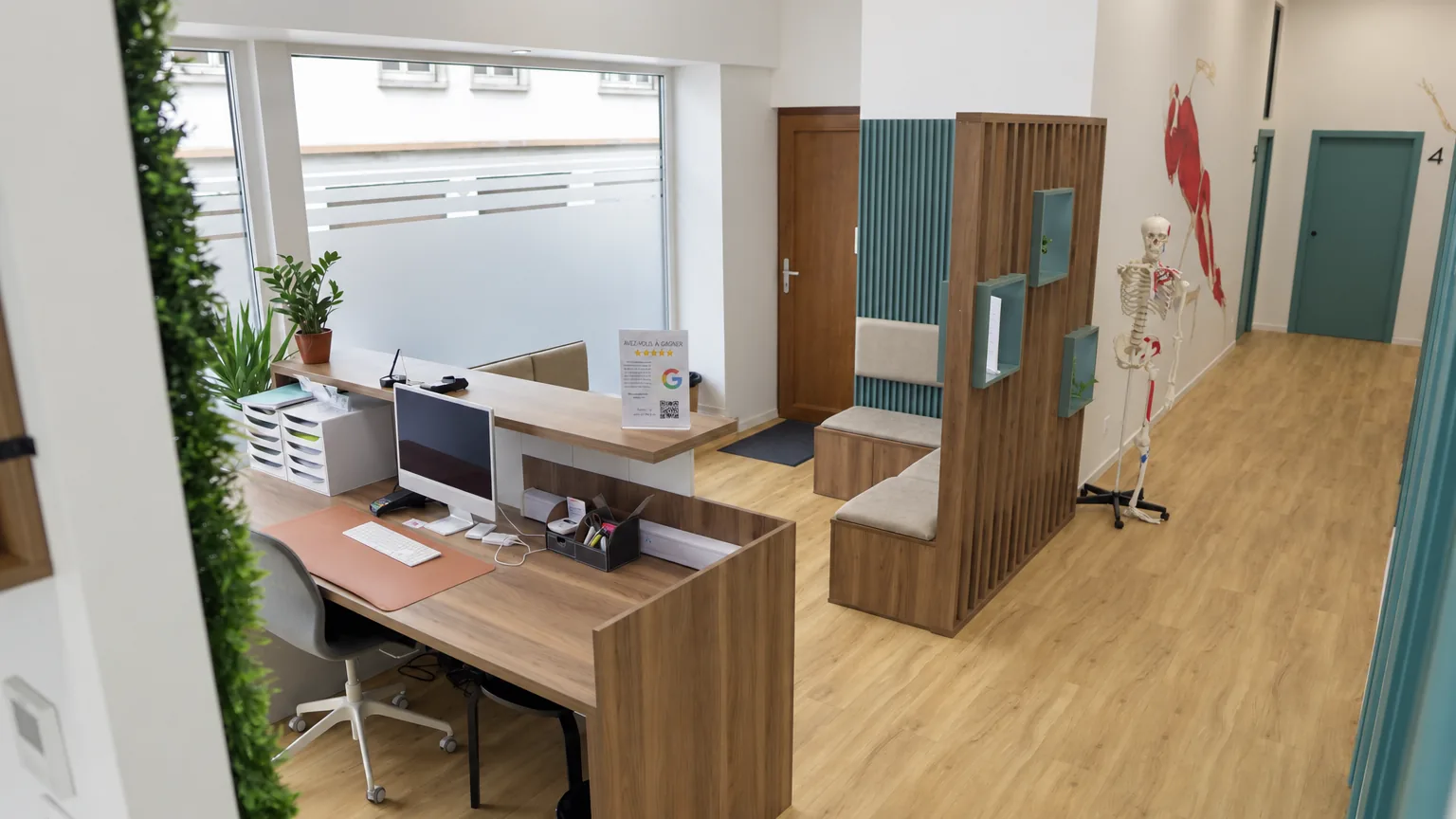 Accueil du cabinet de kiné de Strasbourg : banque d’accueil, assises de la salle d’attente, vitrine dépolie et couloir menant aux box 4 et 5